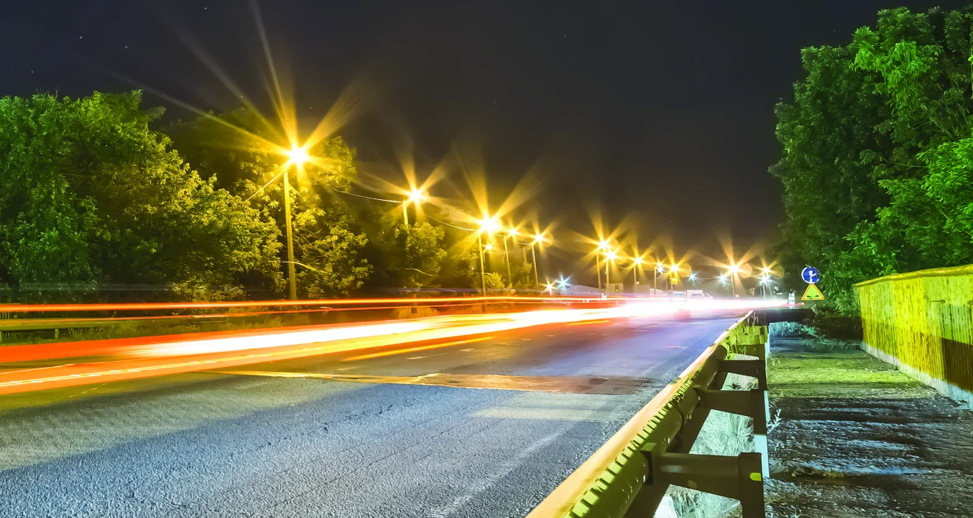 Streetlights illuminating a road and bridge at night